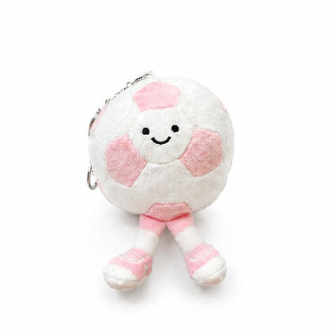 A cute plush keychain shaped like a smiling soccer ball with pink accents and small legs, shown on a clean white background.